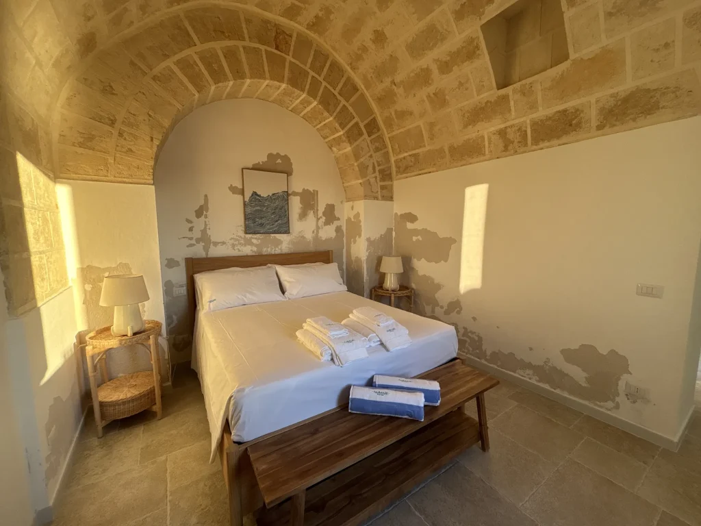 Letto con biancheria bianca e teli Ammare, comodini in rattan