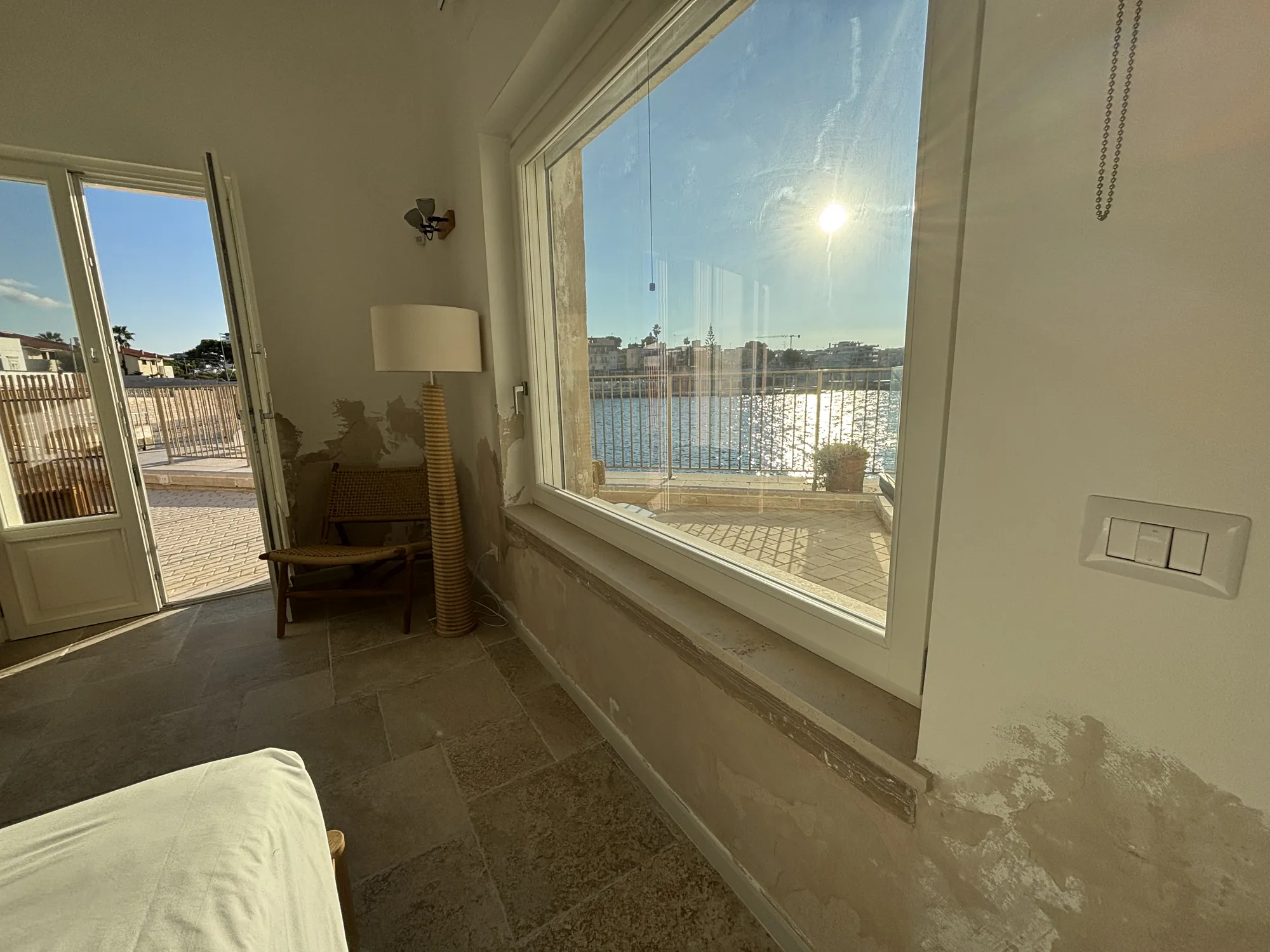 La grande finestra sul lungomare e la portafinestra sulla terrazza