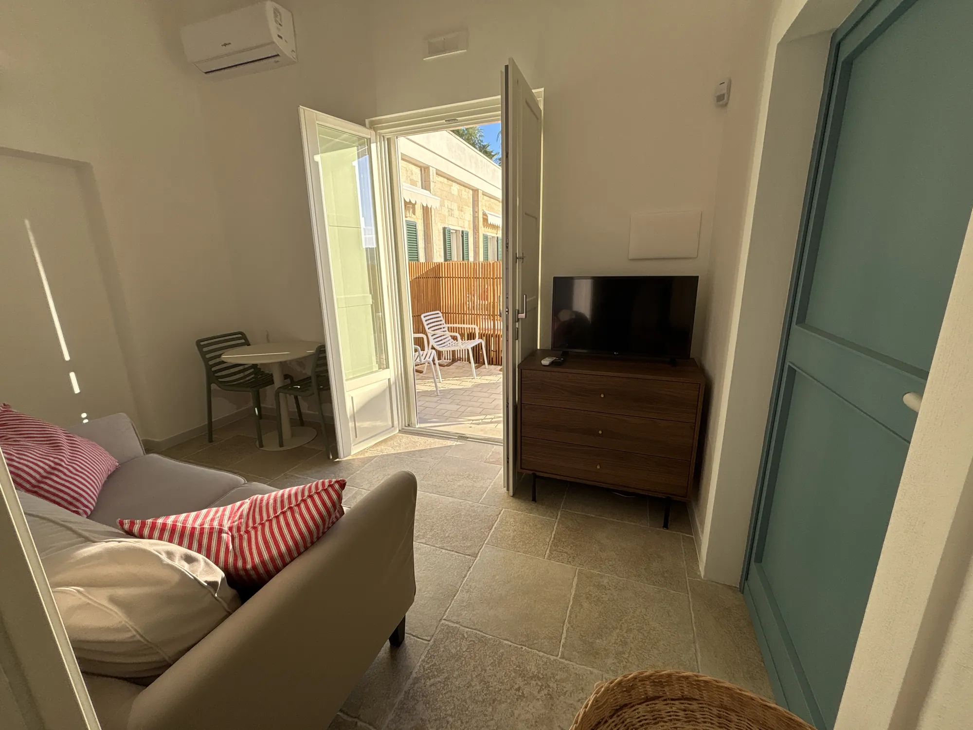 Salottino con TV e portafinestra sulla terrazza con tavolino