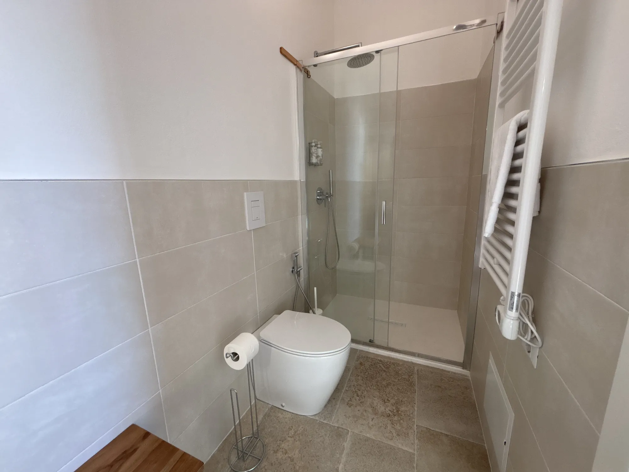 Bagno privato con doccia in vetro e scaldasalviette
