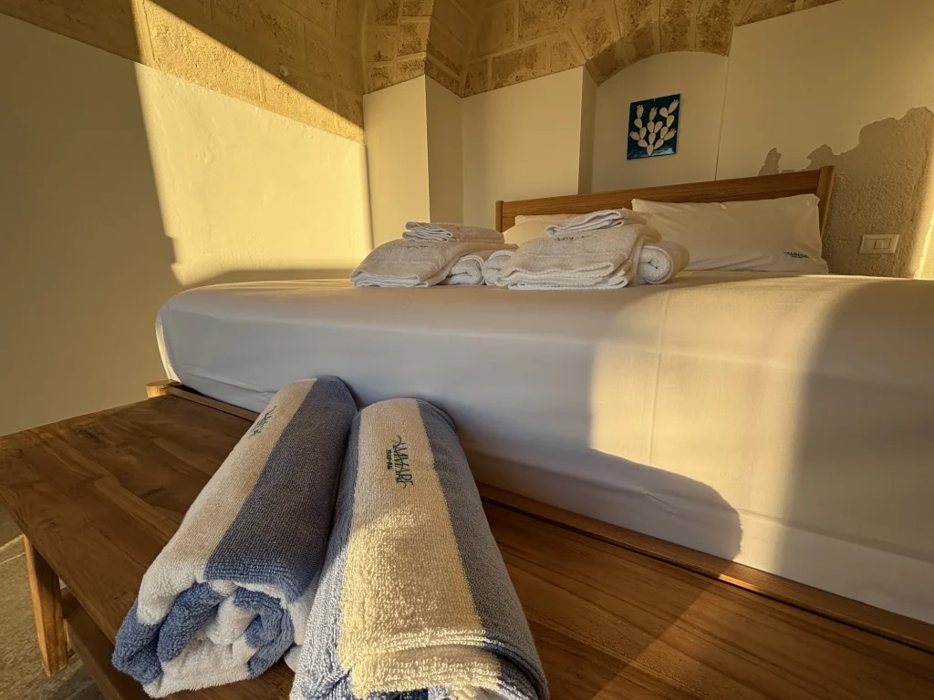 Teli mare Ammare arrotolati sulla panca ai piedi del letto