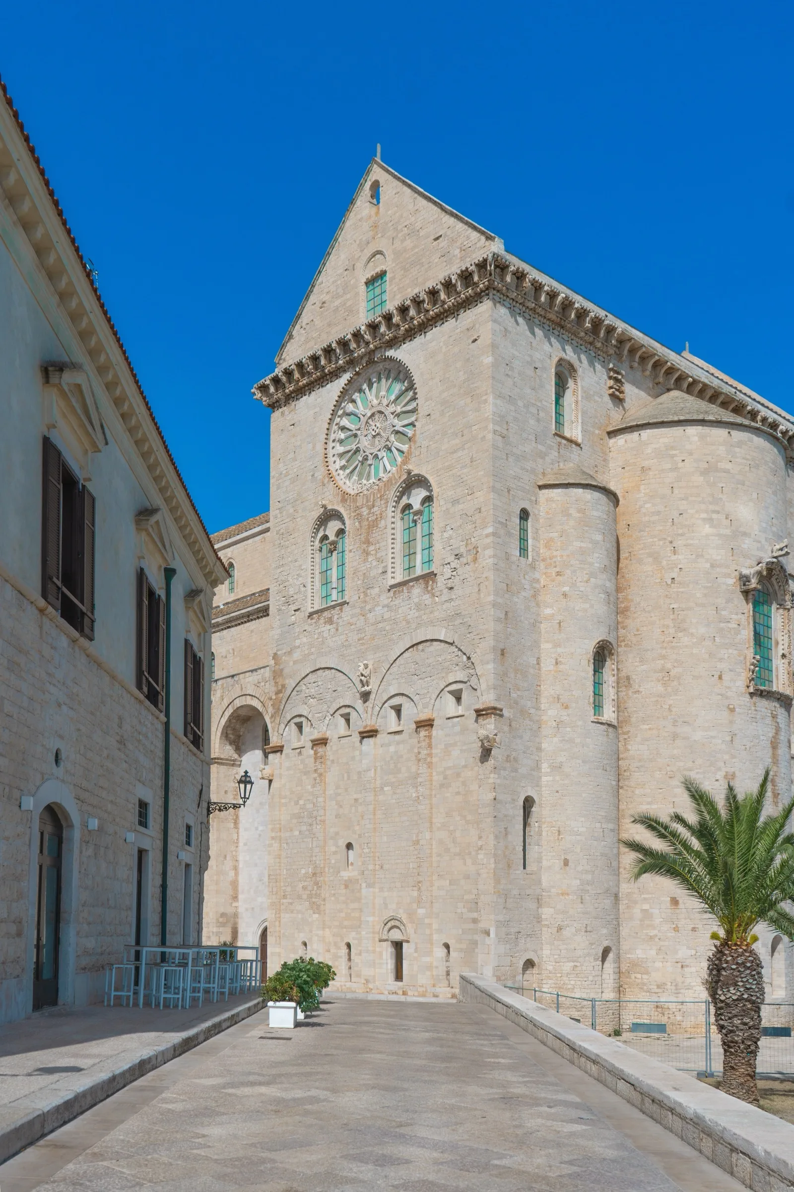 La facciata in pietra chiara della Cattedrale di Trani con il rosone, sotto il cielo azzurro