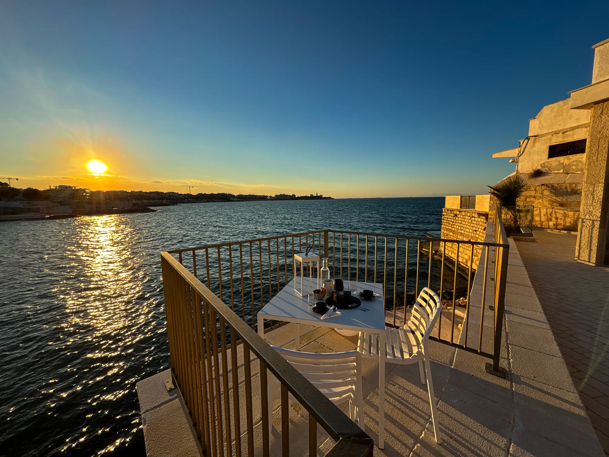 Il tavolo apparecchiato sulla terrazza di Ammare, sul mare di Colonna, al tramonto